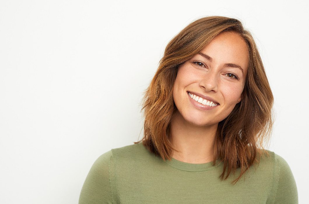 woman smiling after getting CEREC crown