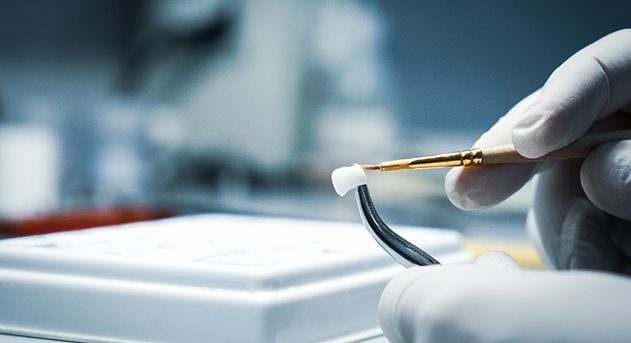 A close-up of a dental crown sitting on a person’s finger