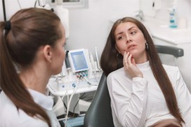 A young woman seeing a dentist for a toothache