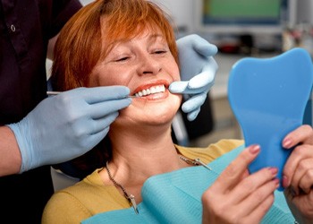 A senior woman admiring her new dental implants