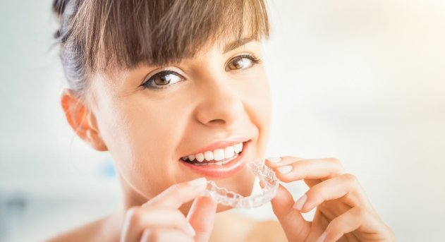 Woman placing an Invisalign tray