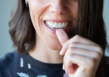 Woman inserting her Invisalign tray