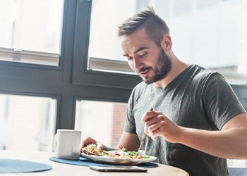 Man enjoying a meal after removing his aligners