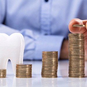 Pile of coins next to a tooth