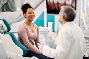 a woman smiling happily during a dental visit